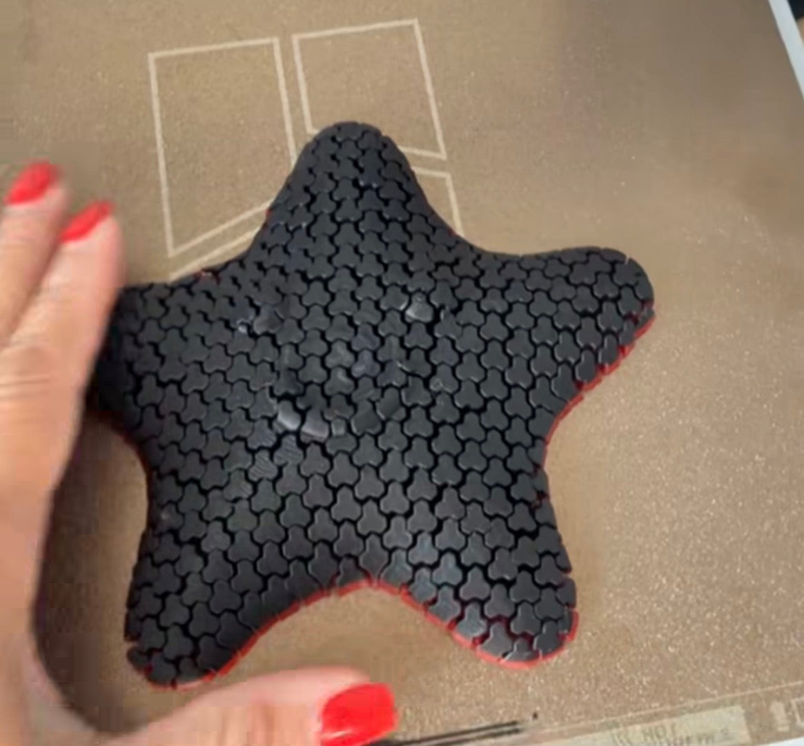 Black articulated star-shaped sensory fidget with red edging