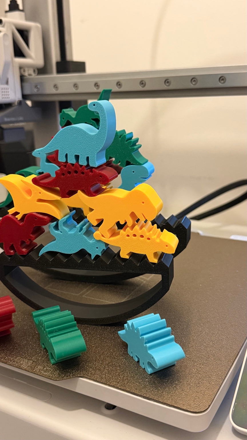 Dinosaur balancing set with yellow blue red and green dinosaur pieces and a black rocking base