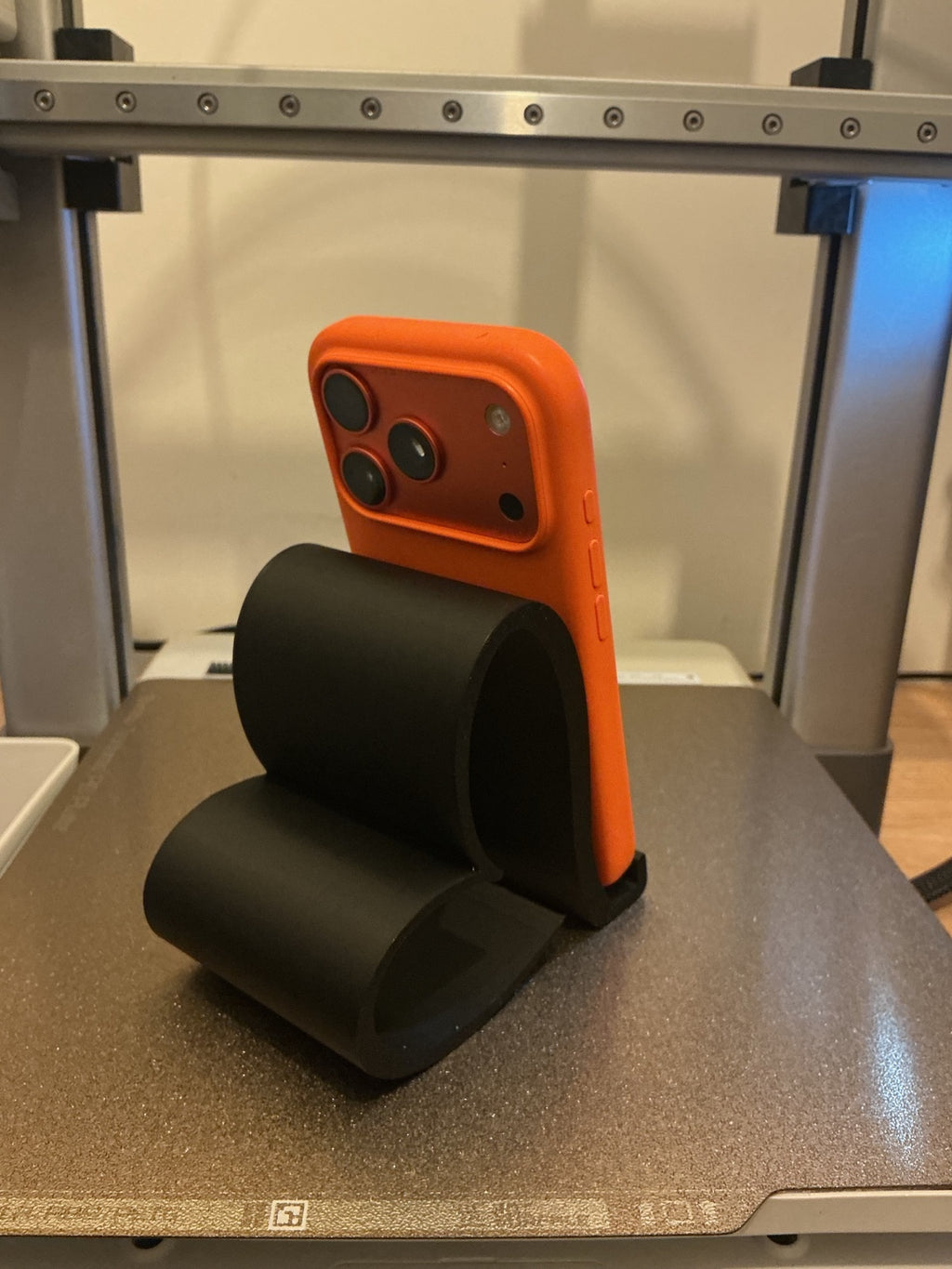 Rear view of a black heart-shaped phone stand holding a phone