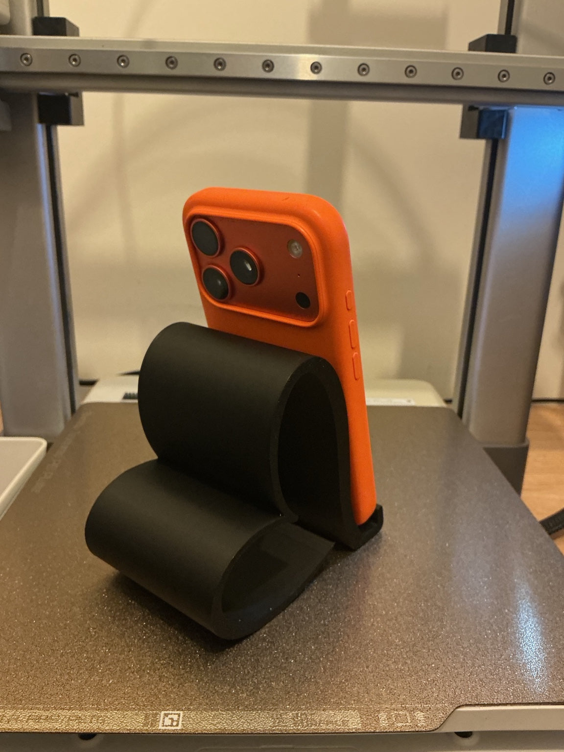 Rear view of a black heart-shaped phone stand holding a phone