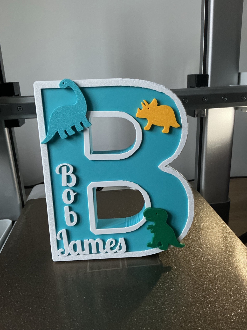 Turquoise and white personalised letter B with dinosaur decorations and Bob James name